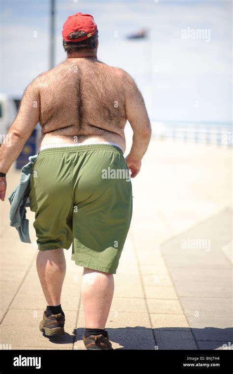 Rear View Of A Large Hairy Man Walking Along Aberystwyth Promenade