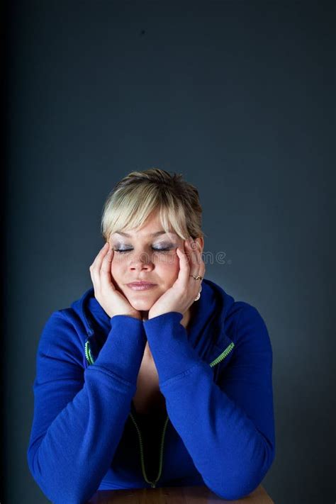 Studio Portrait Of A Cute Blond Girl Bored With Heads In Hands Stock