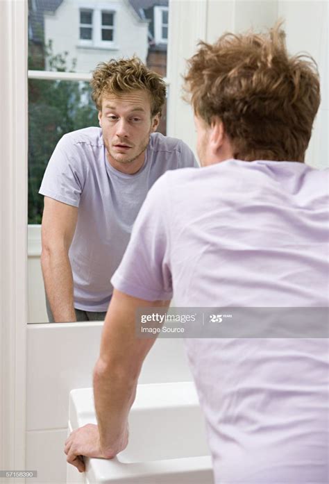 A Man Looking At Himself In The Mirror