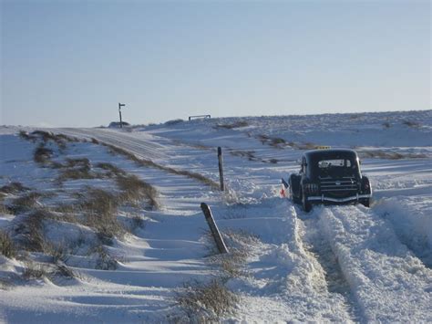 an old truck is driving through the snow