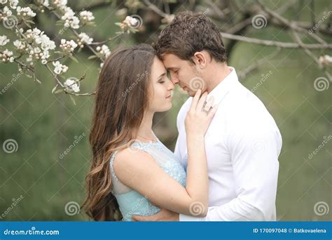 Kissing Newlywed Couple Is Spending Time In The Blooming Garden Stock