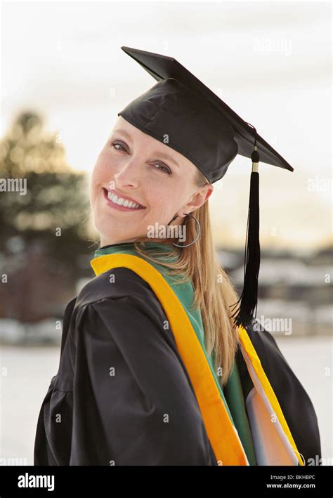 Pretty Blond Caucasian Female In Graduation Cap And Gown Stock Photo