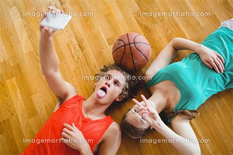 Overhead View Of Friends Taking Selfie While Lying On Floorの写真素材