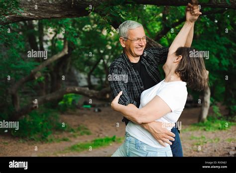 romantic walk through the woods senior couple walking together in a forest close up stock