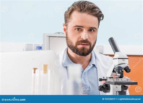 Bearded Scientist Working With Microscope In Laboratory Stock Image