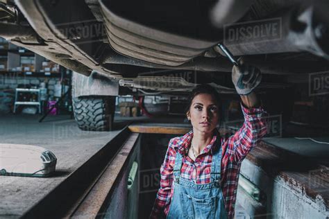Female Mechanic Working Underneath Car At Garage Stock Photo Dissolve