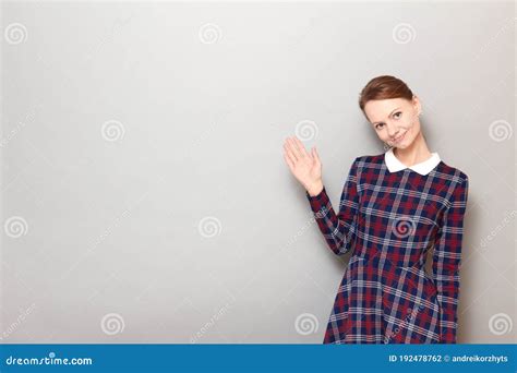Portrait Of Happy Pretty Girl Waving Her Hand And Saying Hello Stock