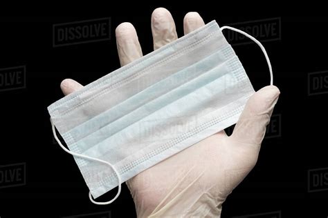 Doctor Holds Face Mask In Hand In White Medical Gloves Isolated On