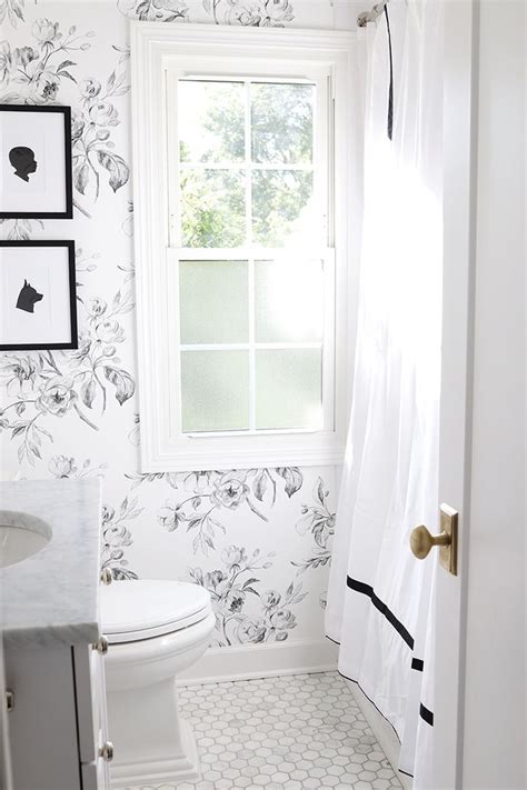 A White Toilet Sitting Next To A Window In A Bathroom With Black And
