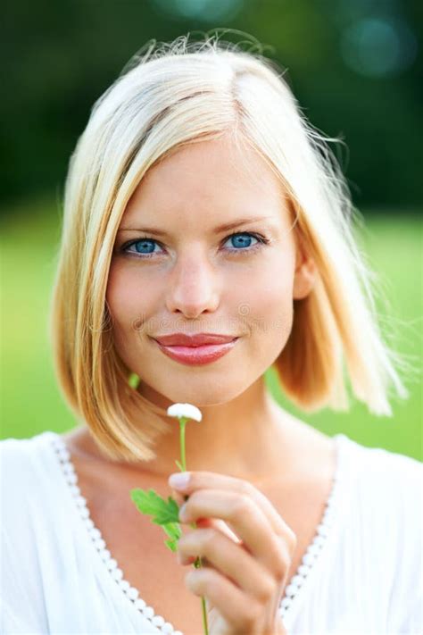 Shes A Natural Stunner Gorgeous Young Woman Holding A Tiny Flower