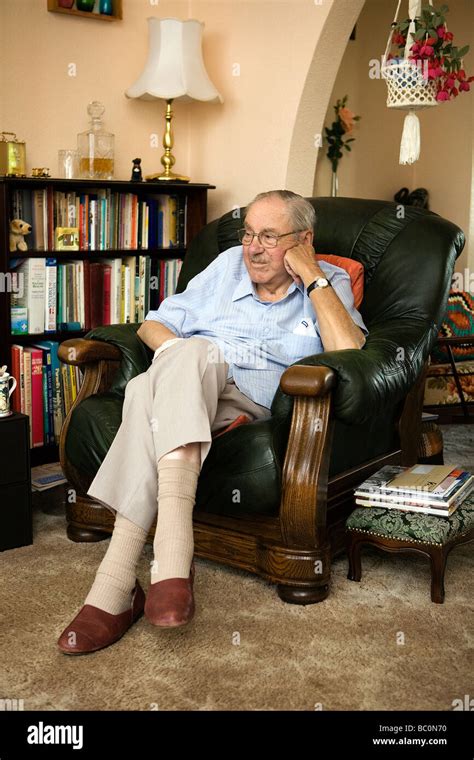 Old Man Sits In His Favourite Armchair Resting His Head Upon His Stock