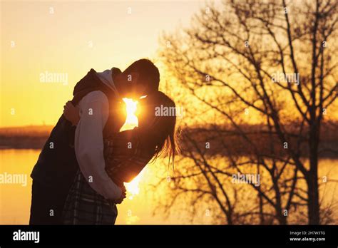 Romantic couple embrace and near the lake at sunset. Lifestyle Candid