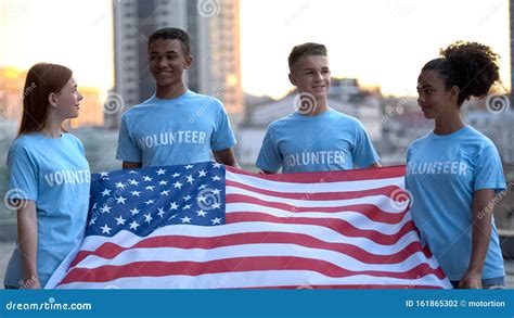 Joyful Multiethnic Volunteers Holding American Flag Charity Project