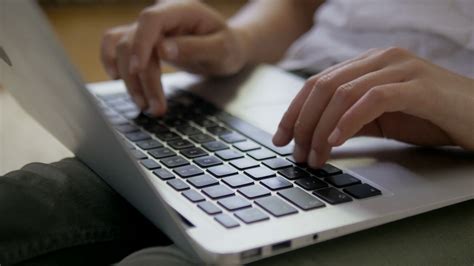 Close-up of female hands typing on the laptop keyboard ...