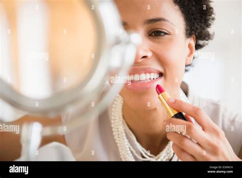 Black Woman Applying Makeup In Mirror Stock Photo Alamy