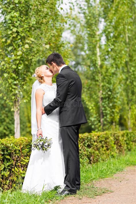 Beautiful Wedding Couple Outdoors They Kiss And Hug Each Other Stock Image Image Of Married
