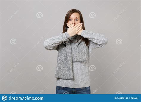 Young Woman In Gray Sweater Scarf Covering Mouth With