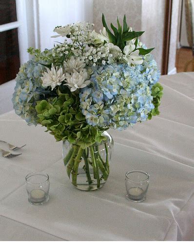 A simple table will surely be enhanced with asters as the centerpiece. Simple white and blue wedding table arrangement photos.PNG