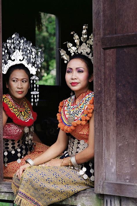 Two Women Dressed In Traditional Thai Garb Sitting On A Window Sill