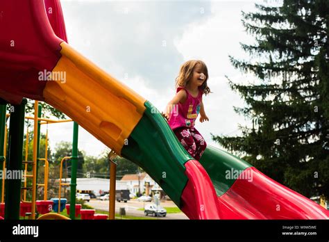 A 4 Year Old Girl On A Colorful Slide On A Playground Stock Photo Alamy