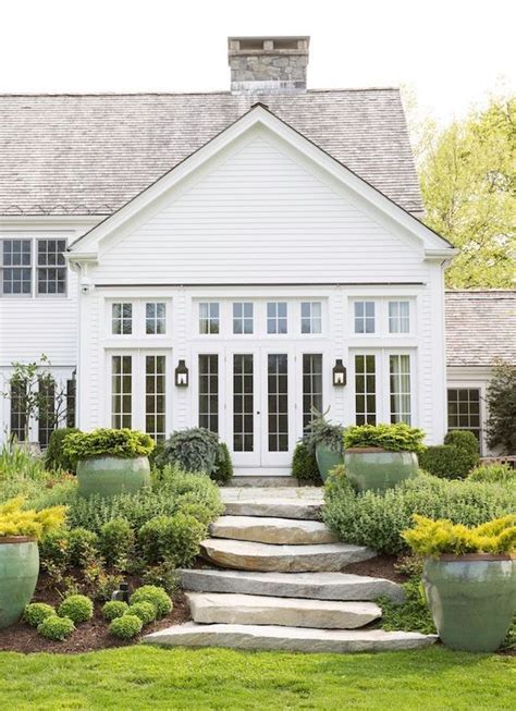 Classic White House With An Organic Feeling Garden Pathway Farmhouse