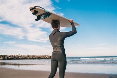 Joven Surfista De Pie En El Océano Con Su Tabla De Surf En Un Traje De