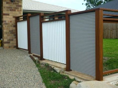 Using wide horizontal panels of corrugated metal, this fence relies on the dark wooden posts to stand strong. sheet metal fence corrugated metal fence panels corrugated ...