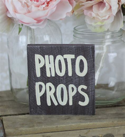 A Wooden Sign That Says Photo Props In Front Of Mason Jars With Flowers