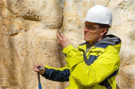 De Geoloog Onderzoekt Een Steekproef Van Steen Openlucht Stock Foto