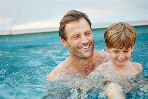 Swimming Lessons With Dad A Father And Son Swimming In A Pool Together