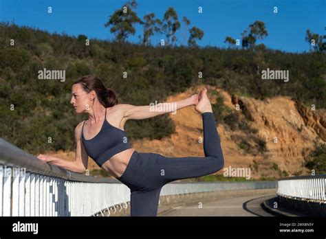 Woman Practicing Yoga And Stretching Outside Dancer Pose Stock Photo