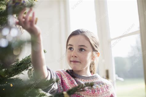Curious Girl Touching Ornament On Christmas Tree Stock Image F022