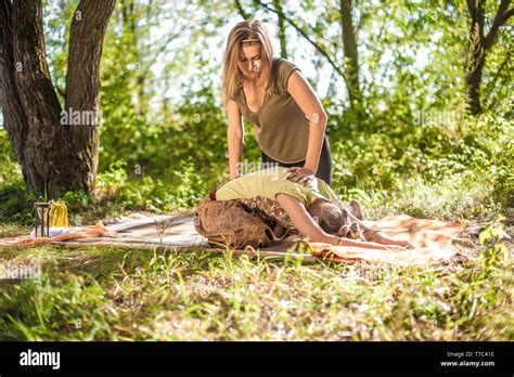 Girl Masseuse Provides A Thorough Massage On The Forest Floor Stock