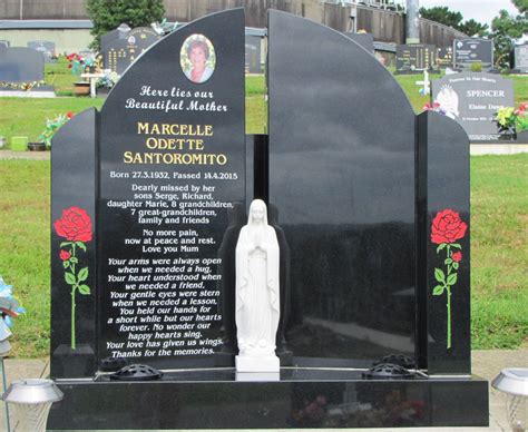 A Statue In The Middle Of A Cemetery With Roses On Its Headstone