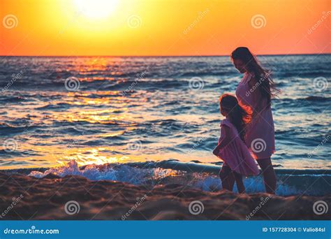 Madre E Hija Jugando Juntos En La Playa Al Atardecer Foto De Archivo