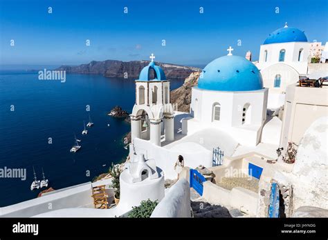 White Washed Stone Buildings Blue Cupolas Church In Oia Hi Res Stock