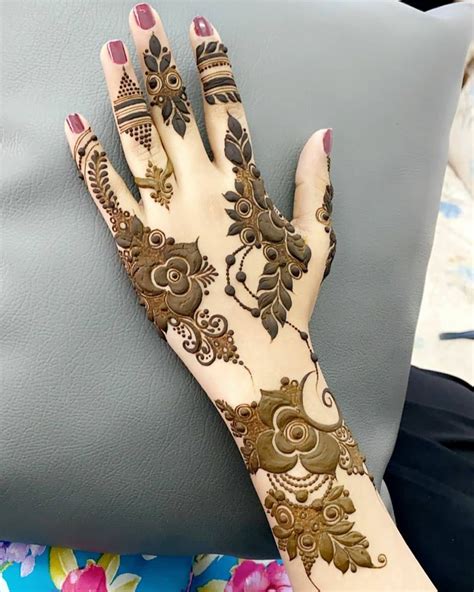A Woman S Hand With Henna Tattoos On It And Her Hands Resting Against A