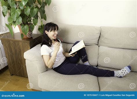 Woman With Glasses Reading A Book On A Sofa Stock Image Image Of
