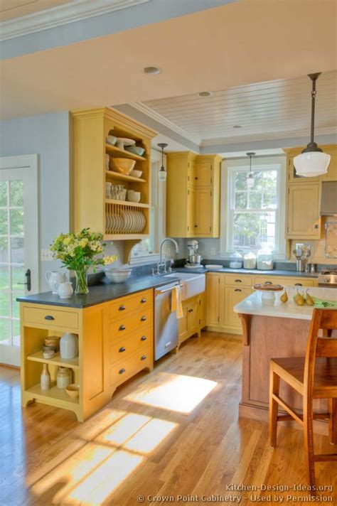 I've been telling my husband i just want to strip my cabinets down to a light natural finish as a compromise. Traditional Yellow Kitchen with a Custom Wood Island