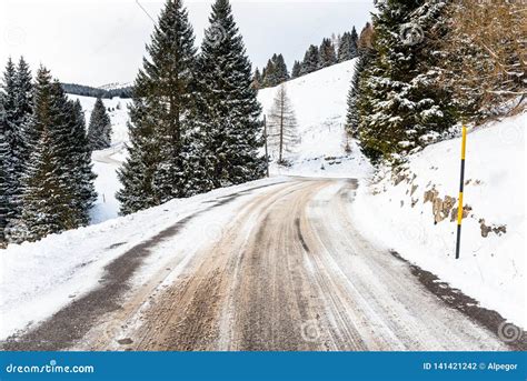 Deserted Winding Mountain Road Covered In Snow In Winter Stock Photo