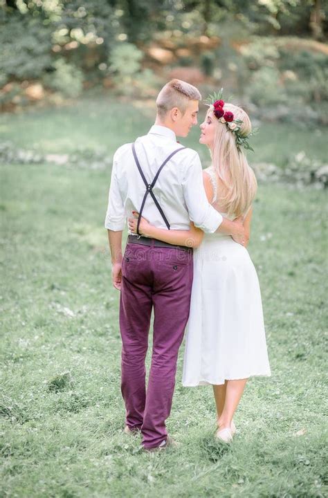 Newlyweds Hug Each Other Waists While Walking In The Grass Stock Image Image Of Beauty Europe