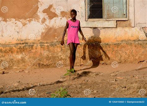 unidentified local girl in pink dress walks along the street in editorial image image of