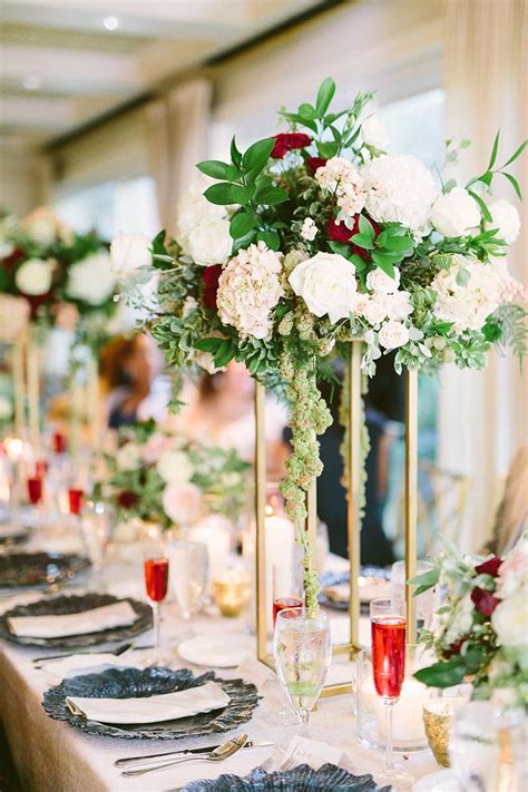 It's not necessary that only exotic flowers are used to make beautiful flower arrangements. gold tall centerpiece. blush burgundy floral. navy accents ...
