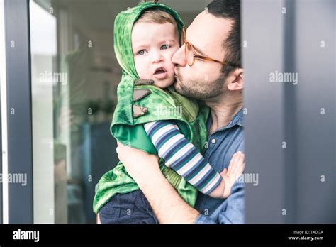 Padre Besando A Su Hijo En Un Traje A La Puerta De La Terraza En Casa