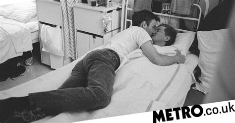 a man and woman laying in a hospital bed