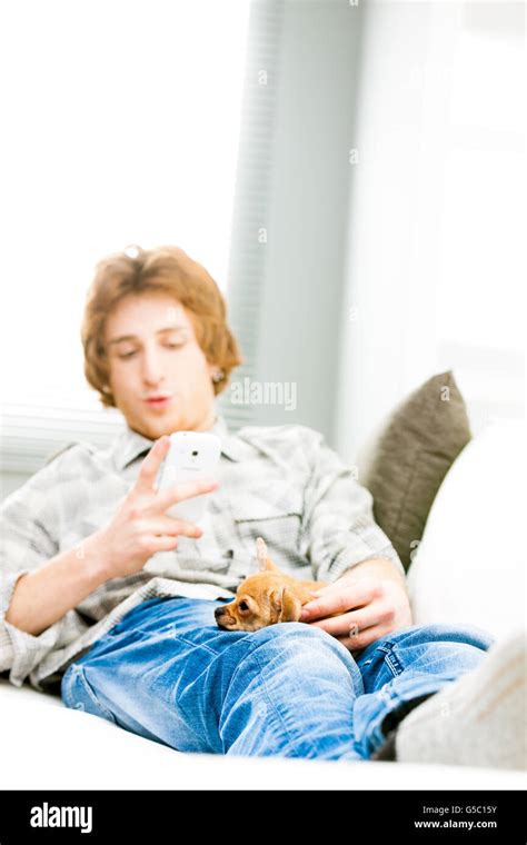 Young Man Spending A Relaxing Day With His Dog Lying Together On The