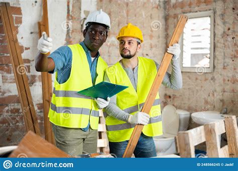 Two Builders Take Notes Evaluating The Work Plan Stock Image Image