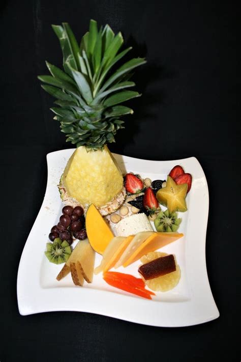 Display Of Assorted Fruits Cheese And Nuts On A White Plate With A