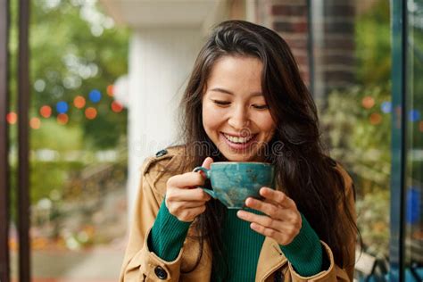 Portrait Of Cute Young Asian Woman Drinking Coffee On Terrace Of Cafe