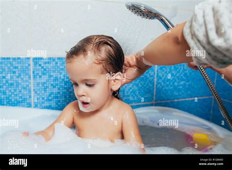 schönes kleines mädchen in der badewanne ein kind wird mit wasser und